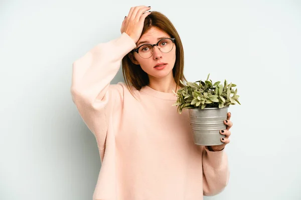 Jovem Inglesa Segurando Uma Planta Isolada Fundo Azul Sendo Chocada — Fotografia de Stock