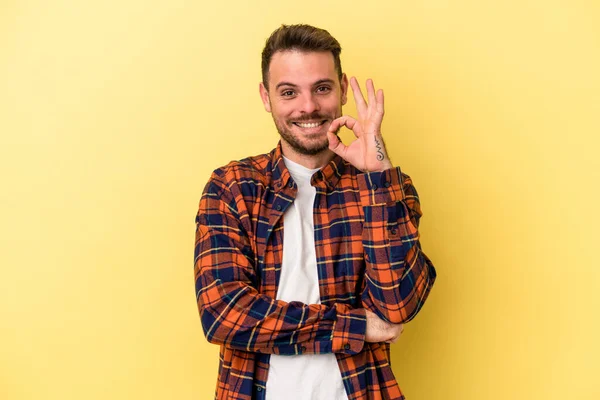 Joven Hombre Caucásico Aislado Sobre Fondo Amarillo Guiña Ojo Sostiene —  Fotos de Stock