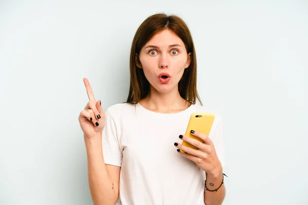 Молодая Английская Женщина Держит Мобильный Телефон Изолирован Синем Фоне Имея — стоковое фото