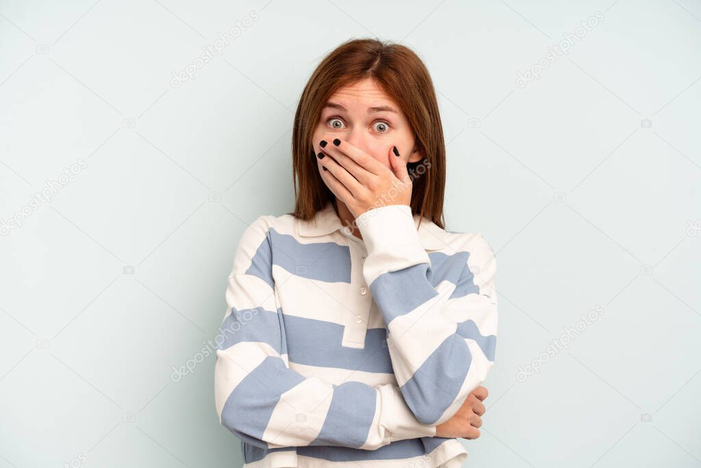 Young English woman isolated on blue background scared and afraid.