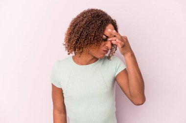 Genç Latin transseksüel kadın pembe arka planda izole edilmiş, başı ağrıyor, yüzüne dokunuyor..