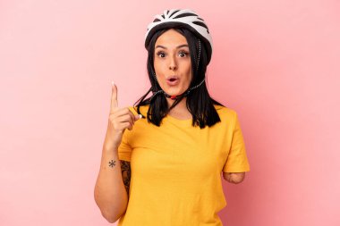 Tek kollu beyaz bir kadın pembe arka planda izole edilmiş bisiklet kaskı takıyor. Harika bir fikri var, yaratıcılık kavramı..
