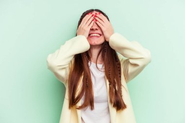 Yeşil arka planda soyutlanmış beyaz bir kadın ellerini başının üstünde tutarak neşeyle gülüyor. Mutluluk kavramı.