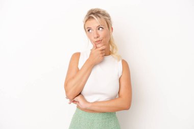 Beyaz arka planda izole edilmiş genç bir Rus kadın şüpheli ve şüpheci bir ifadeyle yana bakıyor..