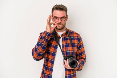 Beyaz arka planda izole edilmiş beyaz tenli genç beyaz fotoğrafçı parmakları dudaklarında bir sır saklıyor..