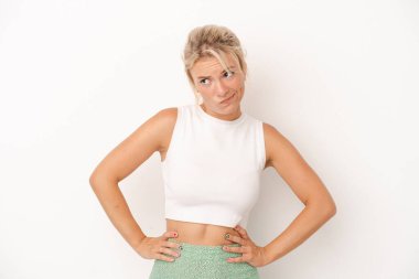 Beyaz arka planda izole edilmiş genç bir Rus kadın kafası karışmış, şüpheli ve güvensiz hissediyor..