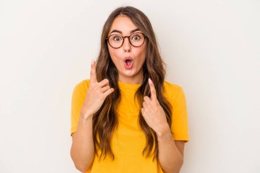 Beyaz arka planda izole edilmiş beyaz bir kadın ağzı açık bir şekilde üst tarafı işaret ediyor..