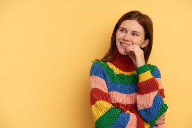 Sarı arka planda izole edilmiş genç bir İngiliz kadın rahatlamış fotokopi odasına bakan bir şey düşünüyor..