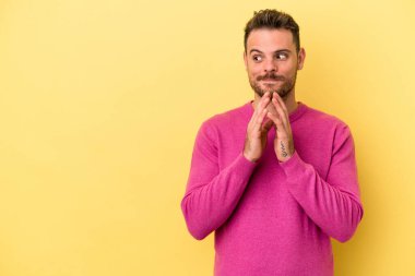 Kafkasyalı genç bir adam sarı arka planda izole edildi. Aklında bir plan oluşturdu..