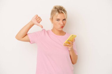 Beyaz arka planda cep telefonu tutan genç Rus kadın gururlu ve kendinden emin hissediyor, örnek olarak.