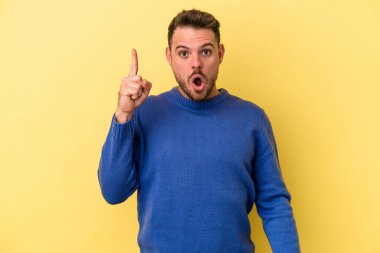 Sarı arka planda izole edilmiş beyaz bir adam ağzı açık bir şekilde üst tarafı işaret ediyor..