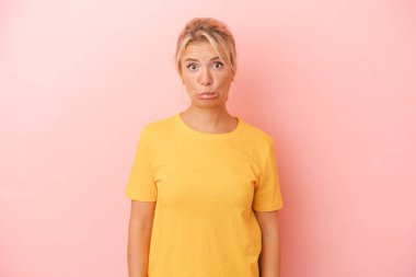 Pembe arka planda izole edilmiş genç bir Rus kadın üzgün, ciddi bir yüz, mutsuz ve hoşnutsuz..