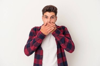 Beyaz arka planda izole edilmiş genç beyaz bir adam ağzı kapalı ve elleri endişeli görünüyor..
