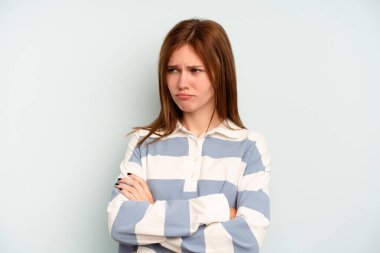 Mavi arka planda izole edilmiş genç bir İngiliz kadın tekrarlanan bir görevden yoruldu.