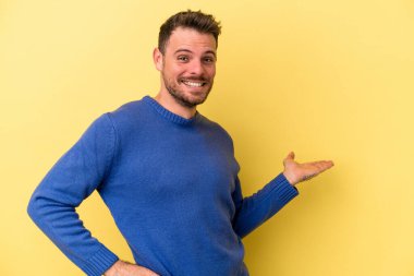 Sarı arka planda izole edilmiş beyaz bir genç hoş bir yüz ifadesi sergiliyor..