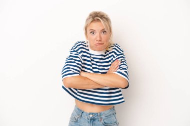 Beyaz arka planda izole edilmiş genç bir Rus kadın omuz silkiyor ve gözleri açık..
