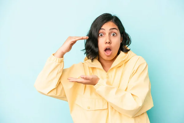 Mujer Latina Joven Aislada Sobre Fondo Azul Sorprendida Sorprendida Sosteniendo — Foto de Stock