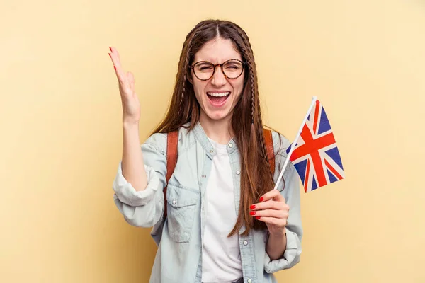 黄色の背景に隔離された英語を勉強している若い白人女性は 興奮し 手を上げる — ストック写真