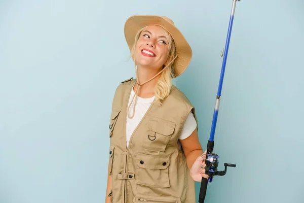 Young Russian Fisherwoman Isolated Blue Background Looks Aside Smiling Cheerful — Stock Photo, Image