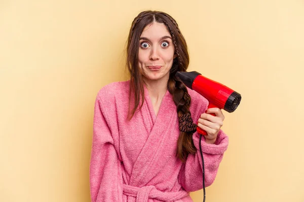 Mujer Joven Sosteniendo Secador Pelo Aislado Sobre Fondo Amarillo Encoge — Foto de Stock