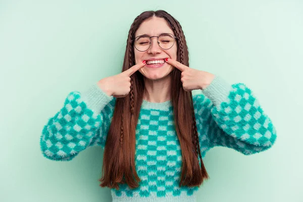 Junge Kaukasische Frau Auf Grünem Hintergrund Lächelt Und Zeigt Mit — Stockfoto