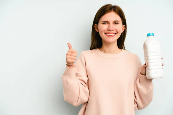 Ung Engelsk Kvinna Håller Flaska Mjölk Isolerad Blå Bakgrund Ler — Stockfoto