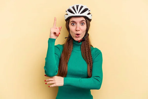 年轻的高加索女人 戴着一顶黄色背景的头盔自行车 有着很好的创意和创意 — 图库照片