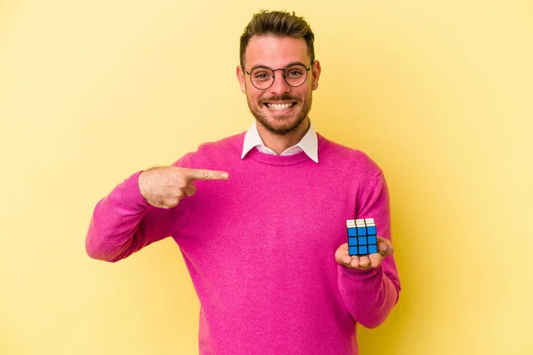 Mladý Běloch Drží Rubiks Kostku Izolované Žlutém Pozadí Osoba Ukazuje — Stock fotografie