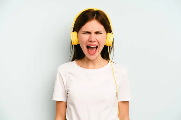 Young English Woman Listening Music Isolated Blue Background Screaming Very — Stock Photo, Image