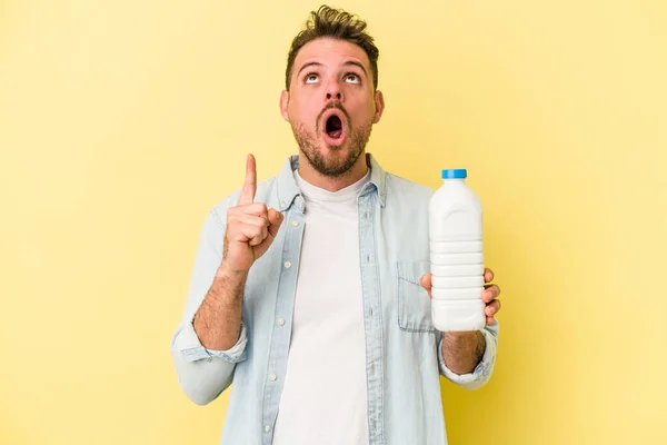 Ung Kaukasier Man Som Håller Flaska Mjölk Isolerad Gul Bakgrund — Stockfoto