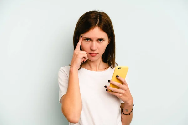 Joven Mujer Inglesa Sosteniendo Teléfono Móvil Aislado Sobre Fondo Azul — Foto de Stock