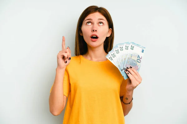 Jonge Engelse Vrouw Met Bankbiljetten Geïsoleerd Blauwe Achtergrond Wijzend Ondersteboven — Stockfoto