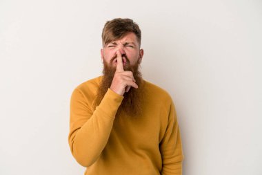 Beyaz arka planda uzun sakallı beyaz tenli genç beyaz adam bir sır saklıyor ya da sessizlik istiyor..