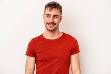 Beyaz arka planda izole edilmiş genç beyaz bir adam parmaklarıyla kaya hareketi gösteriyor.