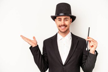 Beyaz arka planda bir değnek tutan Kafkasyalı genç büyücü bir avuç içinin fotokopi çektiğini ve belinde başka bir el tuttuğunu gösteriyor..