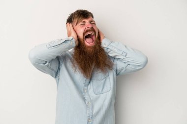 Beyaz arka planda uzun sakallı, beyaz saçlı, elleri kulaklarında, yüksek ses duymamaya çalışan beyaz saçlı genç bir adam..