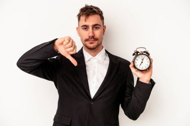 Beyaz arka planda alarm saati tutan Kafkasyalı genç bir iş adamı hoş olmayan bir hareket gösteriyor. Anlaşmazlık konsepti.