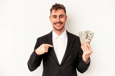 Beyaz arka plandaki insanlardan izole edilmiş, gururlu ve kendinden emin bir şekilde gömlek fotokopi alanını gösteren beyaz banknotlar tutan beyaz iş adamı.