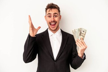Beyaz arka planda izole edilmiş banknotlar tutan Kafkasyalı genç iş adamı hoş bir sürpriz alıyor, heyecanlı ve el kaldırıyor..