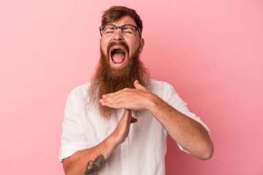 Pembe arka planda uzun sakallı, beyaz, genç bir adam..