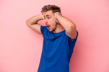 Pembe arka planda izole edilmiş genç beyaz bir adam çığlık atıyor, çok heyecanlı, tutkulu, bir şeyden memnun..