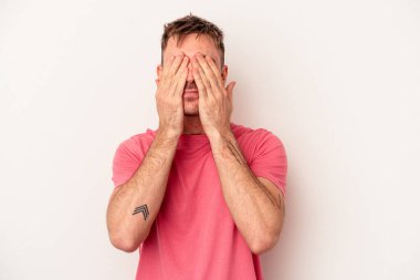 Beyaz arka planda izole edilmiş genç beyaz bir adam ya sır saklıyor ya da sessizlik istiyor..