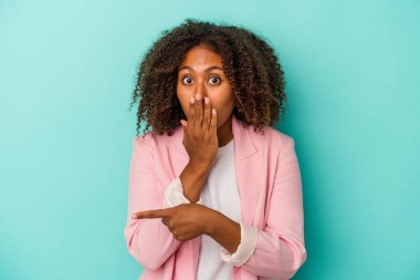Mavi arka planda yalıtılmış kıvırcık saçlı Afro-Amerikan kadın.