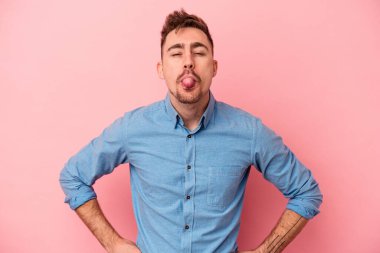 Genç, beyaz bir adam pembe arka planda izole edilmiş komik ve dost canlısı bir dil kullanıyor..