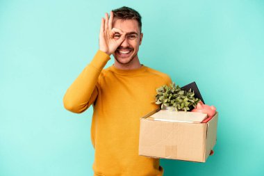 Kafkasyalı genç bir adam mavi arka planda izole edilmiş bir hareket yapıyor..