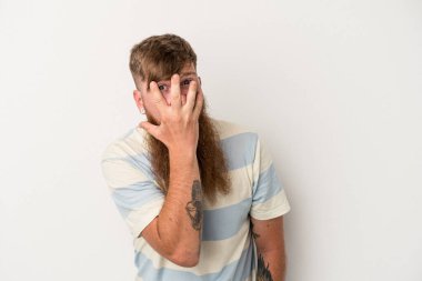 Beyaz arka planda uzun sakallı, beyaz tenli beyaz bir adam korkmuş ve gergin parmaklarıyla göz kırp..