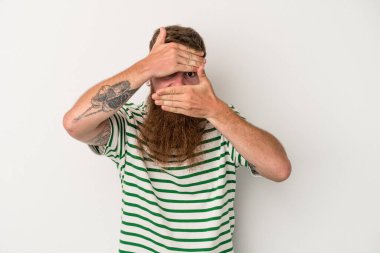 Beyaz arka planda uzun sakallı beyaz tenli beyaz bir adam kameraya parmaklarıyla göz kırpıyor, yüzünü kapatmaktan utanıyor..