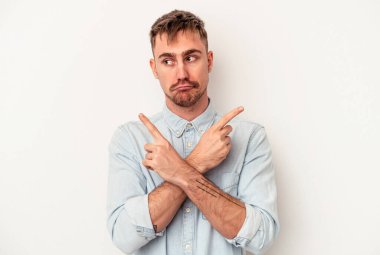 Beyaz arka planda izole edilmiş genç beyaz adam gökyüzüne haykırıyor, yukarı bakıyor, hayal kırıklığına uğramış..