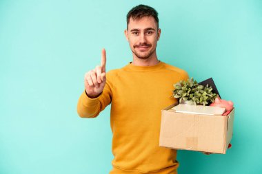 Kafkasyalı genç bir adam mavi arka planda izole bir hareket yapıyor..