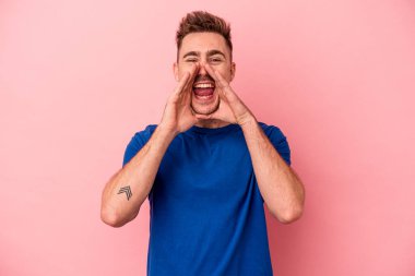 Pembe arka planda izole edilmiş genç beyaz bir adam bir dedikodu söylüyor, bir haber sunuyor..